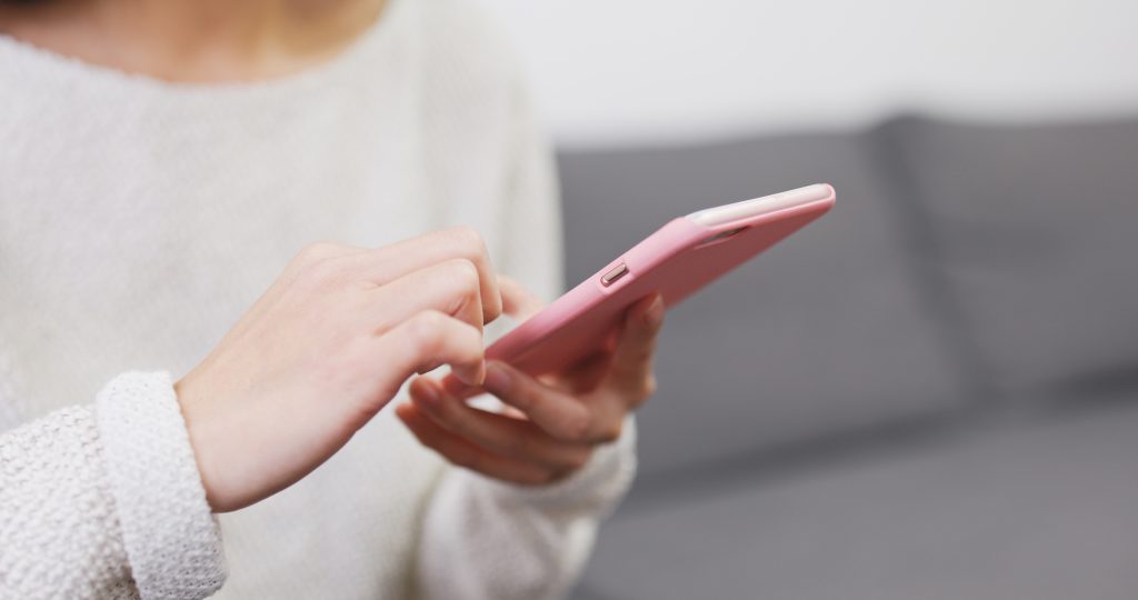 detail rúk mladej ženy, ktorá ovláda mobilný telefón