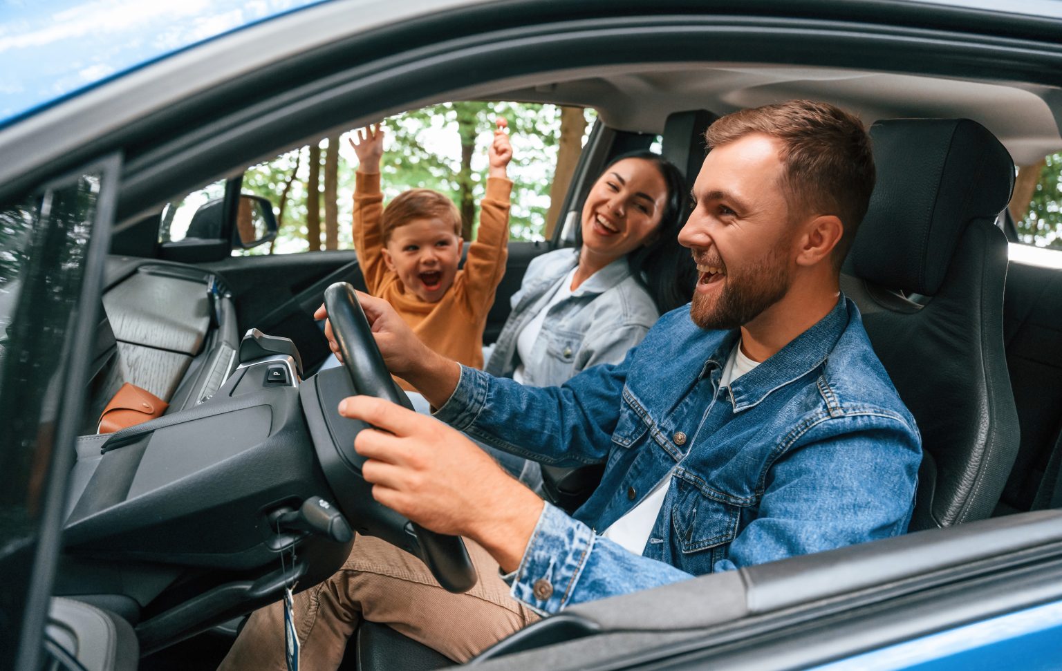 mladá štastný pár v stredných rokoch s dieťatom cestuje v novom automobile na výlet